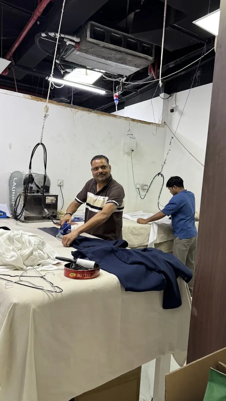 The team at the steam pressing station inside Deep Clean Laundry